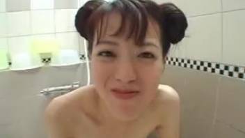 Young Asian girl with pigtails has sex with a large black dog in the bedroom
